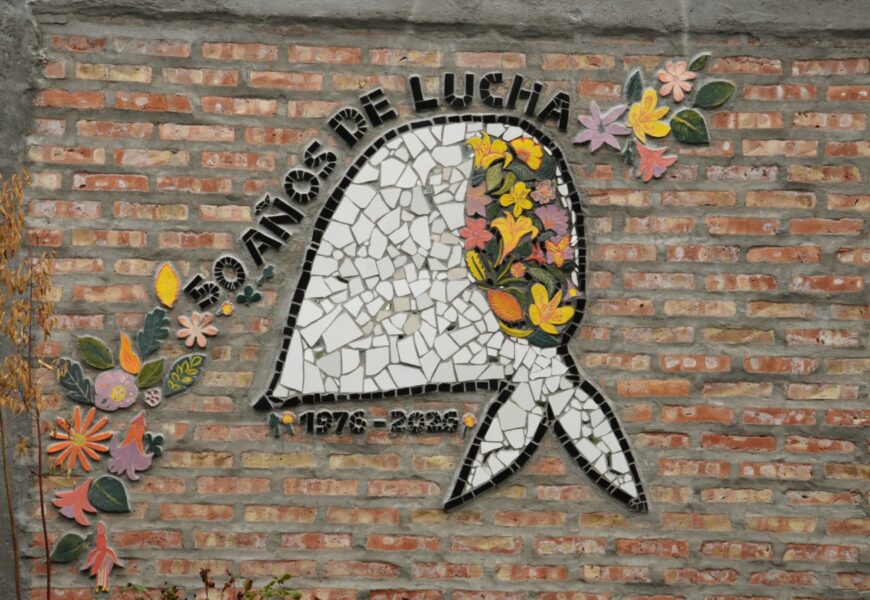 Mural en mosaico con un pañuelo planco característico de las madres y abuelas de Plaza de Mayo del que surgen flores de muchos colores. Sobre el pañuelo se lee la frase: 1976 - 2026 50 años de lucha.